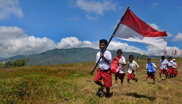 keceriaan anak sekolah yang mengibarkan Bendera Merah Putih